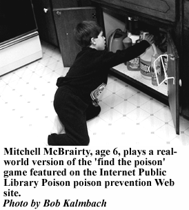 photo, Mitchell McBrairty, age 6, plays a real-world version of the 'find the poison' game featured on the Internet Public Library poison prevention Web site.