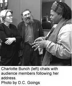 photo of Charlotte Bunch talking with audience members after her address